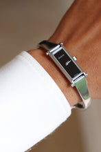 Load image into Gallery viewer, Silver Gucci watch on a wrist with a blurred background
